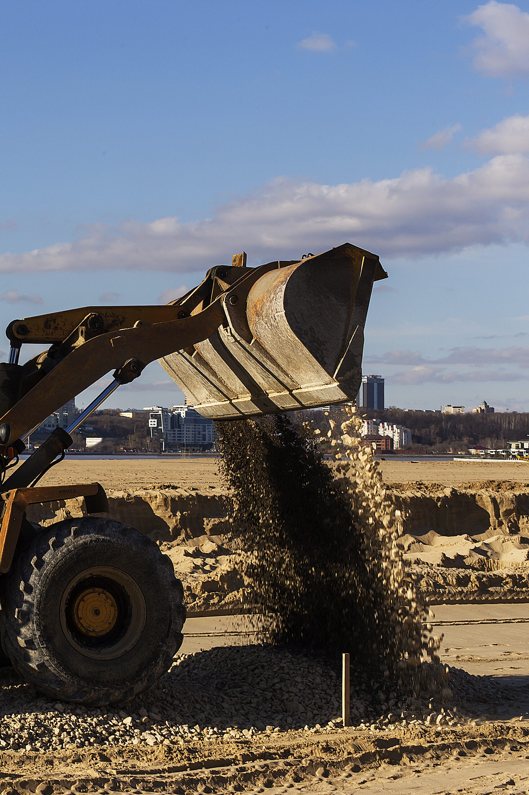 a tractor pours the gravel from the bucket